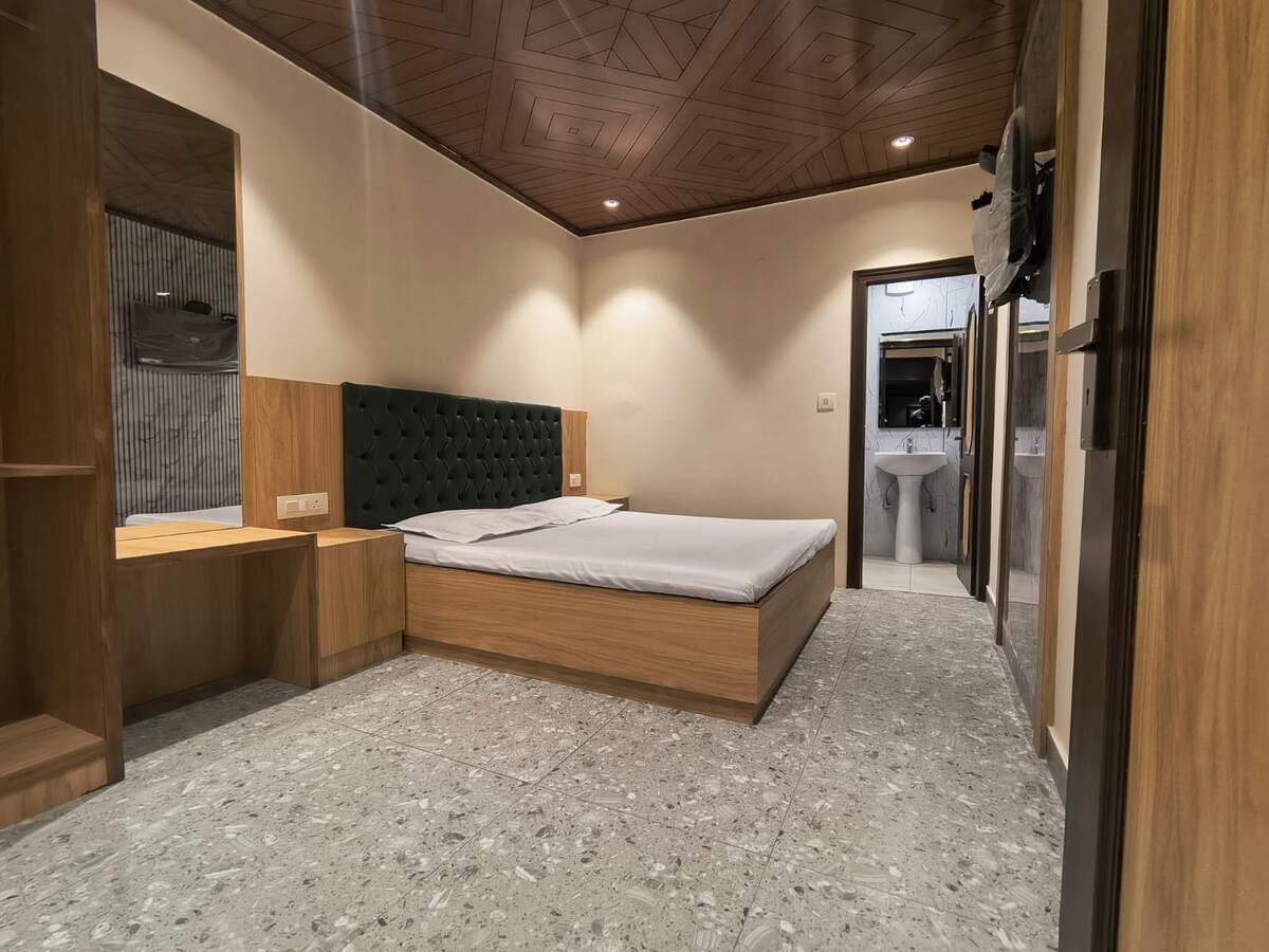 Guest room with green tufted headboard and attached bathroom
